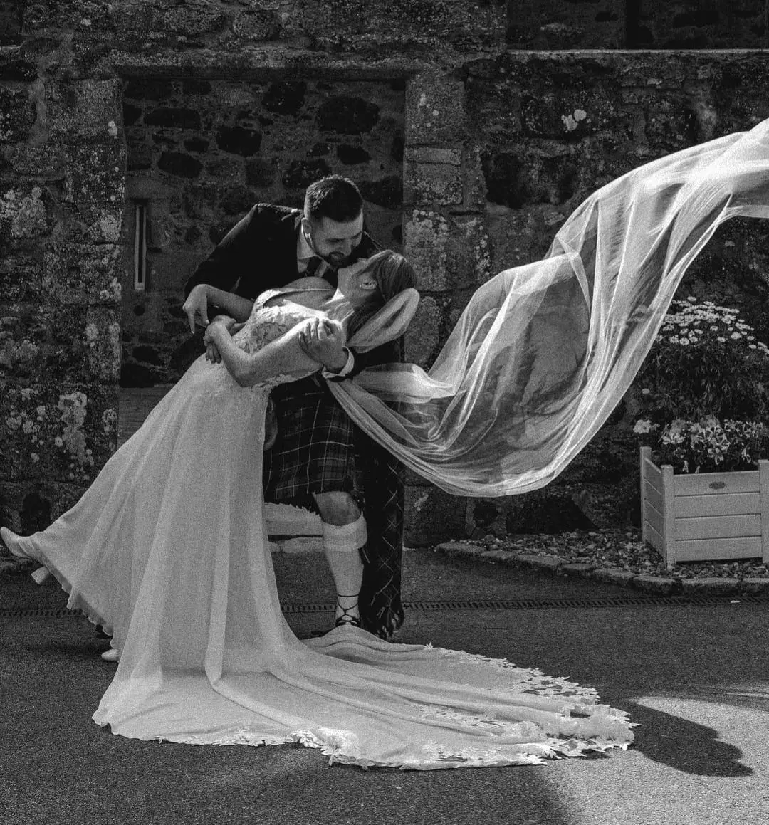 Bride and groom beneath a softly flowing veil